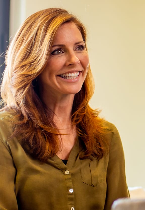 Woman smiling with sun on her hair.