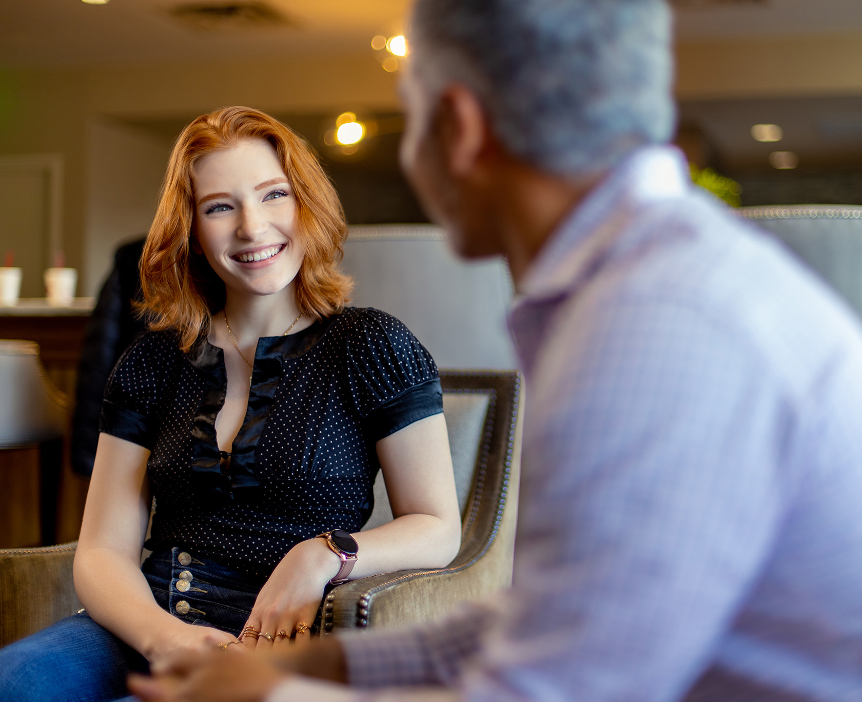 orange haired smiling woman at The LaVie Institute sitting in chair with man in background
