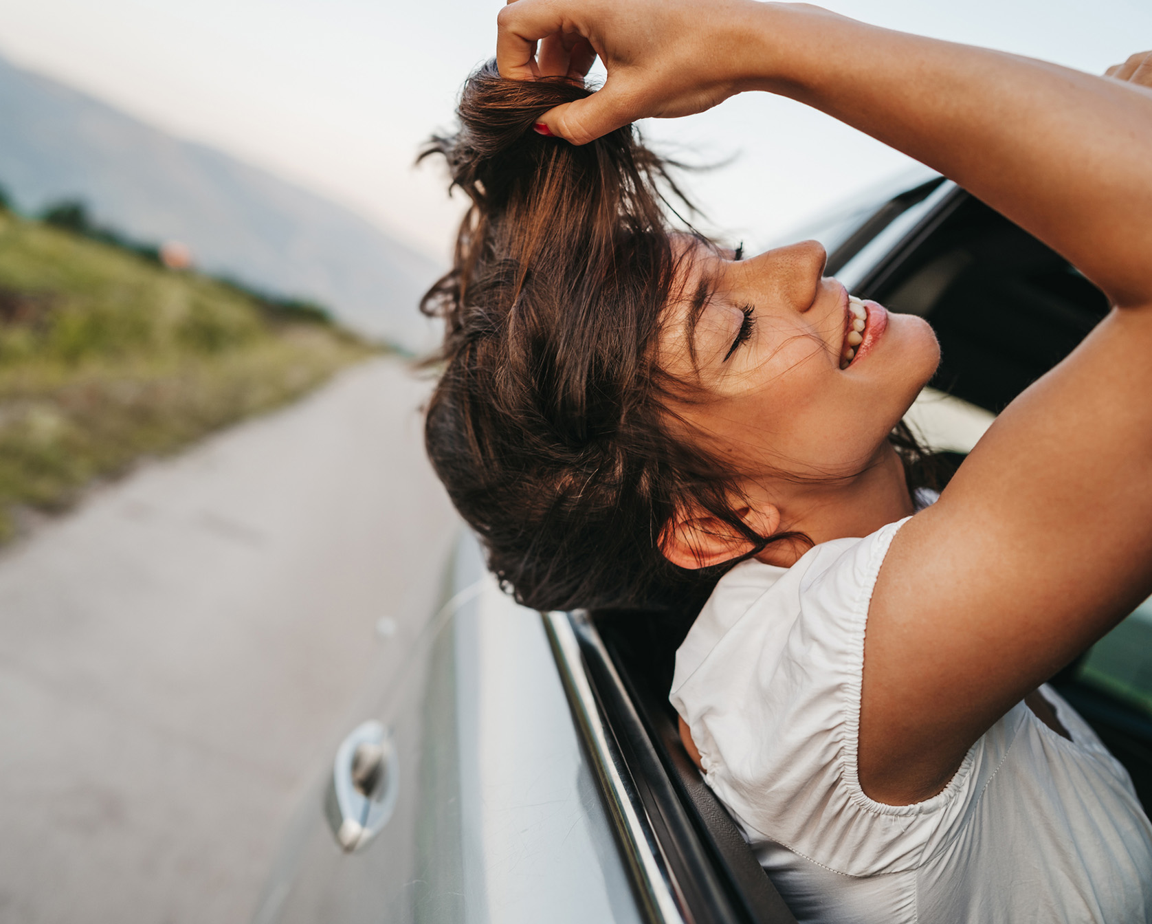 Woman hanging head out of car window