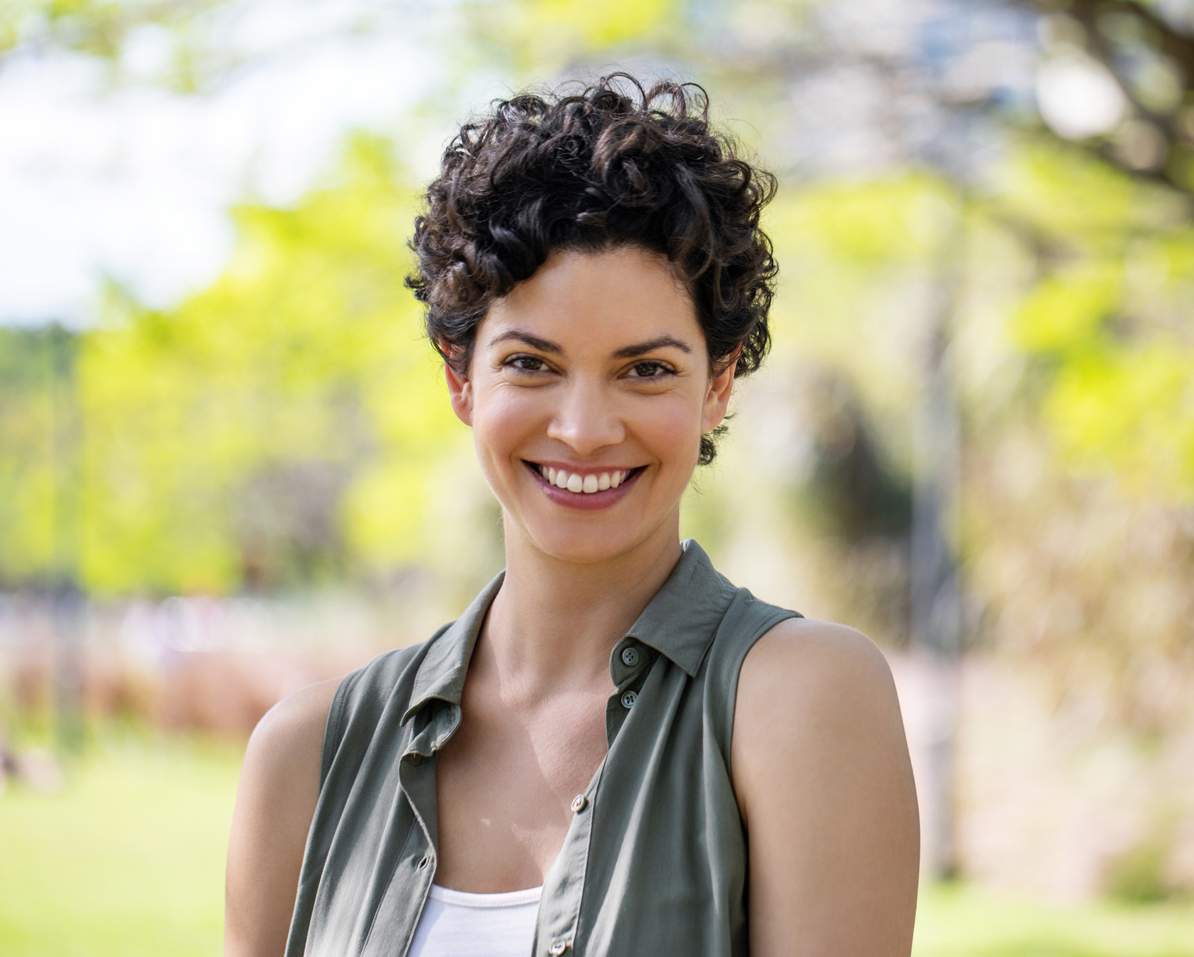 Woman with curly black hair smiling