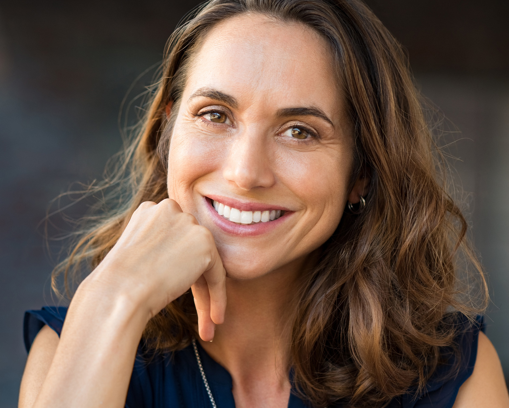 smiling woman with hand on chin